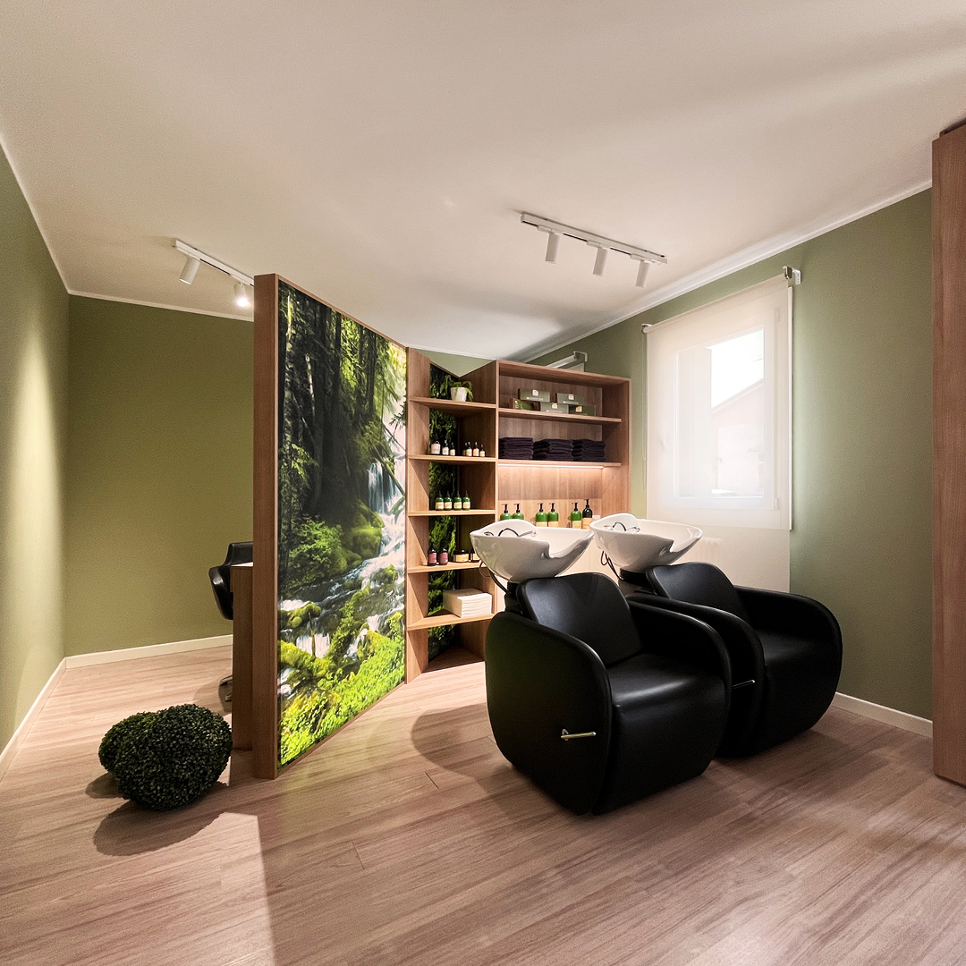 Immagine dell'area lavaggio del salone con focus sui lavaggi neri e dietro Physia T con telo retroilluminato